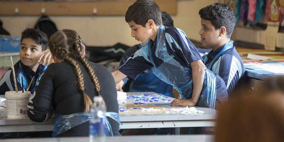 Children in an art classroom using materials.