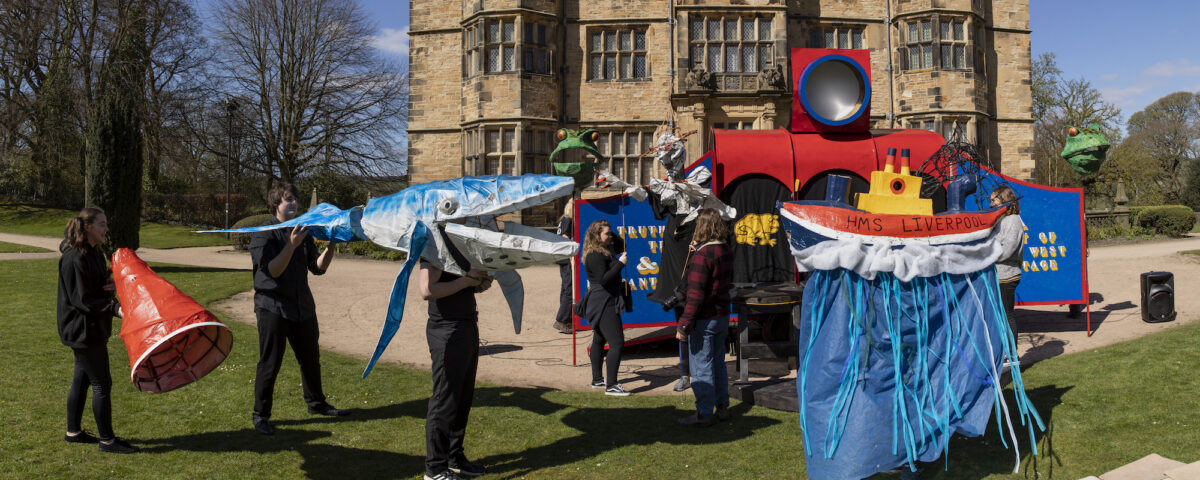 Young people and creatives are pictured in front of Gawthorpe Hall in Padiham. They have created large and colourful models, one represents a ship called HMS Liverpool and one is a whale.
