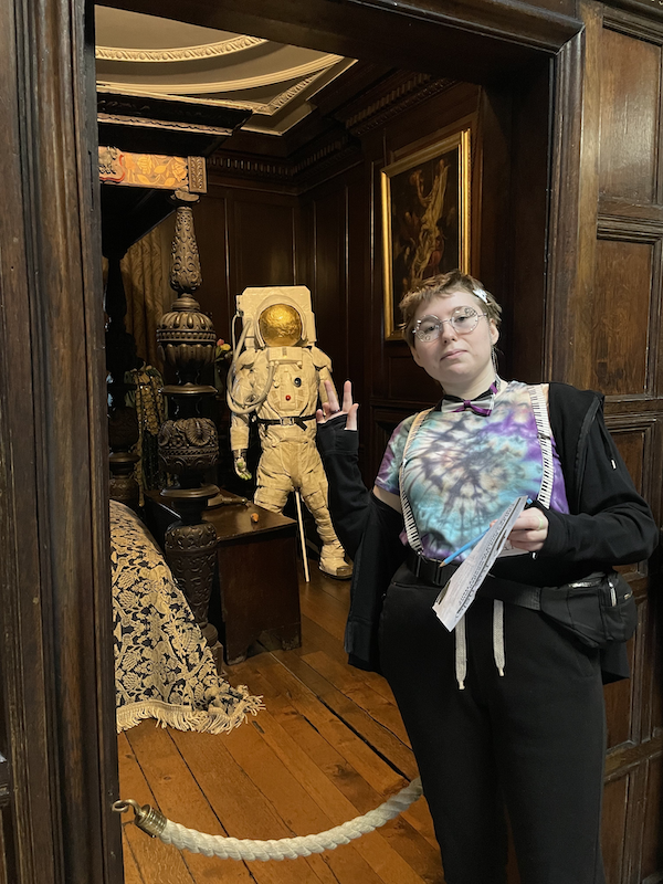 Libby is stood in a heritage venue. She is looking directly at the camera.