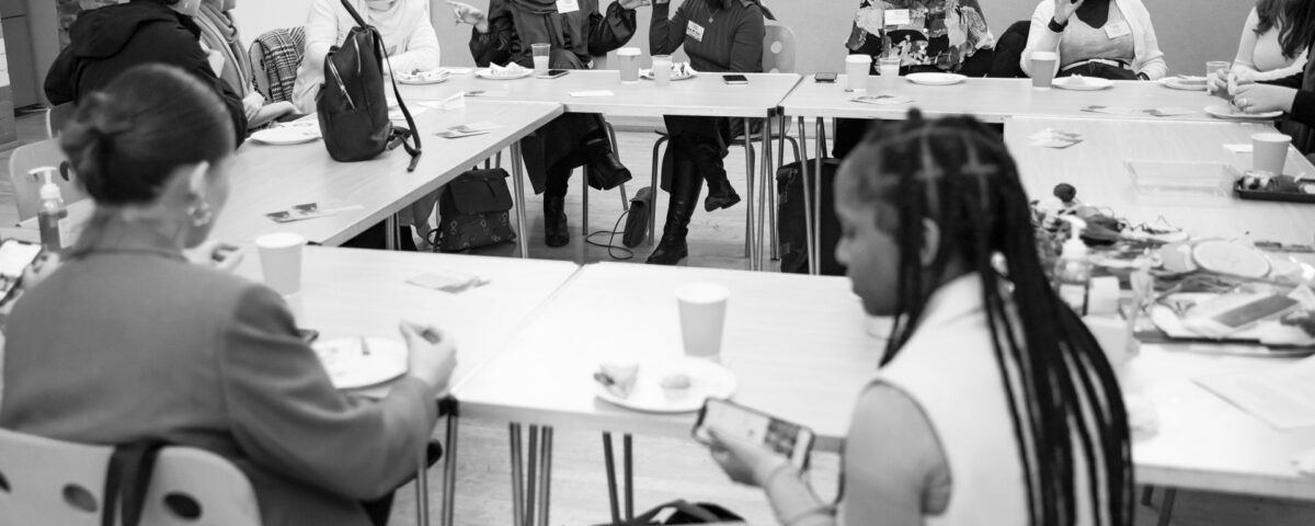A group of young people engaged in conversations around a table.